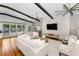 Bright living room with hardwood floors, beamed ceilings, decorative fireplace, and access to outdoor pool at 132 Giralda Ne Blvd, St Petersburg, FL 33704