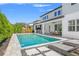 A beautiful backyard featuring a sparkling pool, lush landscaping, and an outdoor kitchen and dining area at 13859 Sharp Hawk Dr, Riverview, FL 33569