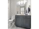 Bathroom with gray vanity cabinet, gold fixtures, and marble floors at 13859 Sharp Hawk Dr, Riverview, FL 33569