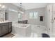 Luxurious bathroom with a soaking tub, double vanity, elegant chandelier, and a modern glass-enclosed shower at 13859 Sharp Hawk Dr, Riverview, FL 33569