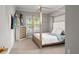Bedroom with a four-poster bed, TV, light-colored walls, and natural light from the windows at 13859 Sharp Hawk Dr, Riverview, FL 33569