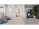 Relaxing bedroom with a large bed, arched mirror, and view into hall at 13859 Sharp Hawk Dr, Riverview, FL 33569