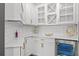 Well-appointed butler's pantry features white cabinetry, quartz countertops, wine storage, and stylish gold hardware at 13859 Sharp Hawk Dr, Riverview, FL 33569