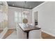 Bright dining room boasts modern chandelier, plantation shutters, and a large wooden table for Gathering gatherings at 13859 Sharp Hawk Dr, Riverview, FL 33569