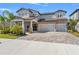 Charming two-story home with a three-car garage, stone accents, and well-manicured landscaping at 13859 Sharp Hawk Dr, Riverview, FL 33569