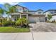 Attractive two-story home with a three-car garage and well-manicured lawn on a sunny day at 13859 Sharp Hawk Dr, Riverview, FL 33569