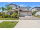 Beautiful two-story home with a three-car garage, well-manicured lawn, and tasteful landscaping at 13859 Sharp Hawk Dr, Riverview, FL 33569