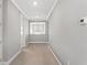 Neutral hallway with crown molding, carpet, and a window at the end of the hall with a chandelier at 13859 Sharp Hawk Dr, Riverview, FL 33569