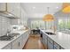 Bright, open kitchen with island, modern appliances, and ample counter space flowing into the dining and living areas at 13859 Sharp Hawk Dr, Riverview, FL 33569