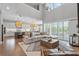 Open-concept living room with high ceilings, large windows, and modern furnishings flowing into the kitchen area at 13859 Sharp Hawk Dr, Riverview, FL 33569