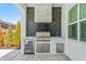 Outdoor kitchen with stone backsplash, stainless steel grill, mini fridge, and sink at 13859 Sharp Hawk Dr, Riverview, FL 33569