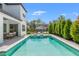 Backyard swimming pool with a stone deck, lounge chairs, landscaping, and a view of the home's exterior at 13859 Sharp Hawk Dr, Riverview, FL 33569