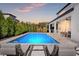 Stunning pool and patio area featuring luxurious lounge chairs and a built-in outdoor kitchen, perfect for entertaining at 13859 Sharp Hawk Dr, Riverview, FL 33569