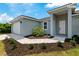 Exterior view of a home with a manicured lawn, paver walkway, and a two car garage at 14024 Wenzel Ave, Port Charlotte, FL 33981