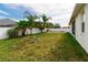 Expansive backyard with a white fence, palm trees, and a well-maintained lawn, ideal for outdoor enjoyment at 14027 Bensbrook Dr, Spring Hill, FL 34609