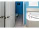 Bright bathroom featuring a soaking tub with tile surround and blue accent wall, with a glimpse of the toilet area at 14027 Bensbrook Dr, Spring Hill, FL 34609