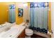 Bathroom featuring a toilet, and shower/tub combo with a colorful patterned curtain, and a yellow wall at 14027 Bensbrook Dr, Spring Hill, FL 34609