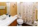 Bathroom featuring a vanity with a sink, toilet, and a shower/tub combination with a seashell patterned curtain at 14027 Bensbrook Dr, Spring Hill, FL 34609