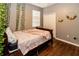 Cozy bedroom featuring a wooden bed frame, hardwood floors, a window with natural light, and a decorative wreath at 14027 Bensbrook Dr, Spring Hill, FL 34609