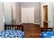 Bedroom with two twin beds with dinosaur-themed sheets, dark wood floors, and gray walls at 14027 Bensbrook Dr, Spring Hill, FL 34609