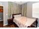A gray bedroom featuring a dark wood bed with a nightstand and decorative vines hanging on the walls at 14027 Bensbrook Dr, Spring Hill, FL 34609