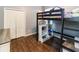 A cozy bedroom featuring a dark wood loft bed with built-in storage and dark wood floors at 14027 Bensbrook Dr, Spring Hill, FL 34609