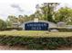 Elegant entrance sign for Amersham Isles, framed by lush hedges and stone pillars at 14027 Bensbrook Dr, Spring Hill, FL 34609