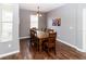 Dining room featuring a wooden table and seating for eight, complemented by wood floors and natural light from the window at 14027 Bensbrook Dr, Spring Hill, FL 34609