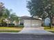 Charming single-story home featuring a well-manicured front yard and an attached two-car garage at 14027 Bensbrook Dr, Spring Hill, FL 34609
