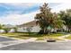 Corner lot home featuring mature landscaping and a well-maintained lawn in a serene neighborhood setting at 14027 Bensbrook Dr, Spring Hill, FL 34609