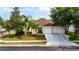 Inviting single-story home with a well-kept lawn, mature trees, and an attached garage with a double door at 14027 Bensbrook Dr, Spring Hill, FL 34609