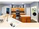 Spacious kitchen featuring stainless steel appliances, wooden cabinetry, and an island with views to the breakfast nook at 14027 Bensbrook Dr, Spring Hill, FL 34609