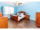 Charming bedroom features wood floors, a ceiling fan, and ample storage space at 14027 Bensbrook Dr, Spring Hill, FL 34609