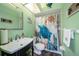 Charming bathroom with a sea turtle theme, vanity sink, and shower with nautical curtain at 14181 Cornewall Ln, Spring Hill, FL 34609