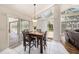 Dining area with white tile floors, modern lighting, and sliding glass doors to the lanai at 14181 Cornewall Ln, Spring Hill, FL 34609