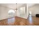 Open dining area with wood floors, a chandelier, and a view of the entryway, providing an airy feel at 14181 Cornewall Ln, Spring Hill, FL 34609