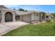 Close up of the home's exterior highlighting the architectural details, garage and manicured garden bed at 14181 Cornewall Ln, Spring Hill, FL 34609