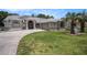 Exterior front view of the house showcasing its architecture, well-kept lawn, and inviting curb appeal at 14181 Cornewall Ln, Spring Hill, FL 34609