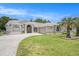 Well-maintained front yard with a circular driveway and manicured landscaping that enhance the home's curb appeal at 14181 Cornewall Ln, Spring Hill, FL 34609