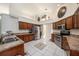 Kitchen featuring wood cabinets, stainless steel appliances, granite counters, and white tile floor with star mosaic at 14181 Cornewall Ln, Spring Hill, FL 34609