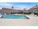 Gorgeous swimming pool with lounge chairs, palm trees, and well-maintained landscaping at 14181 Cornewall Ln, Spring Hill, FL 34609