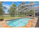 The refreshing screened-in pool is complemented by a large patio area and picturesque outdoor views at 14181 Cornewall Ln, Spring Hill, FL 34609