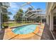 Enjoy the screened-in pool with a spacious deck and beautiful views of the surrounding greenery at 14181 Cornewall Ln, Spring Hill, FL 34609
