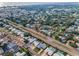 Wide aerial shot of a neighborhood dotted with trees, pools, and access roads under a sunny sky at 14341 Passage Way, Seminole, FL 33776