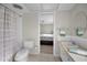 Well-lit bathroom with a combo shower-tub, single sink vanity, and access to the main bedroom at 14341 Passage Way, Seminole, FL 33776