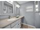 A bathroom includes vanity with sink, two mirrors, and neutral tile flooring at 14341 Passage Way, Seminole, FL 33776
