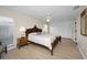A bedroom features an ornate wooden bed frame, neutral walls, and light wood floors at 14341 Passage Way, Seminole, FL 33776
