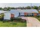 Inviting single-story home with a manicured lawn, brick accents, and a cozy entrance at 14341 Passage Way, Seminole, FL 33776