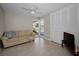Cozy living room filled with natural light and featuring wood look floors, a couch, and a television at 14341 Passage Way, Seminole, FL 33776