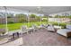 Comfortable covered patio featuring brick flooring, ceiling fan, wicker furniture, and view of backyard at 14341 Passage Way, Seminole, FL 33776